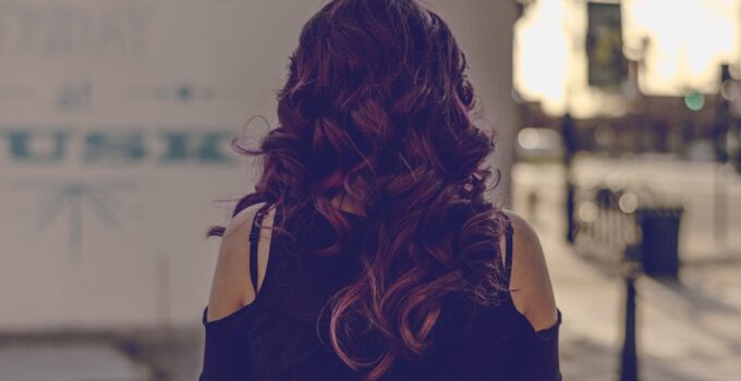 A person learning how to change the part on a wig